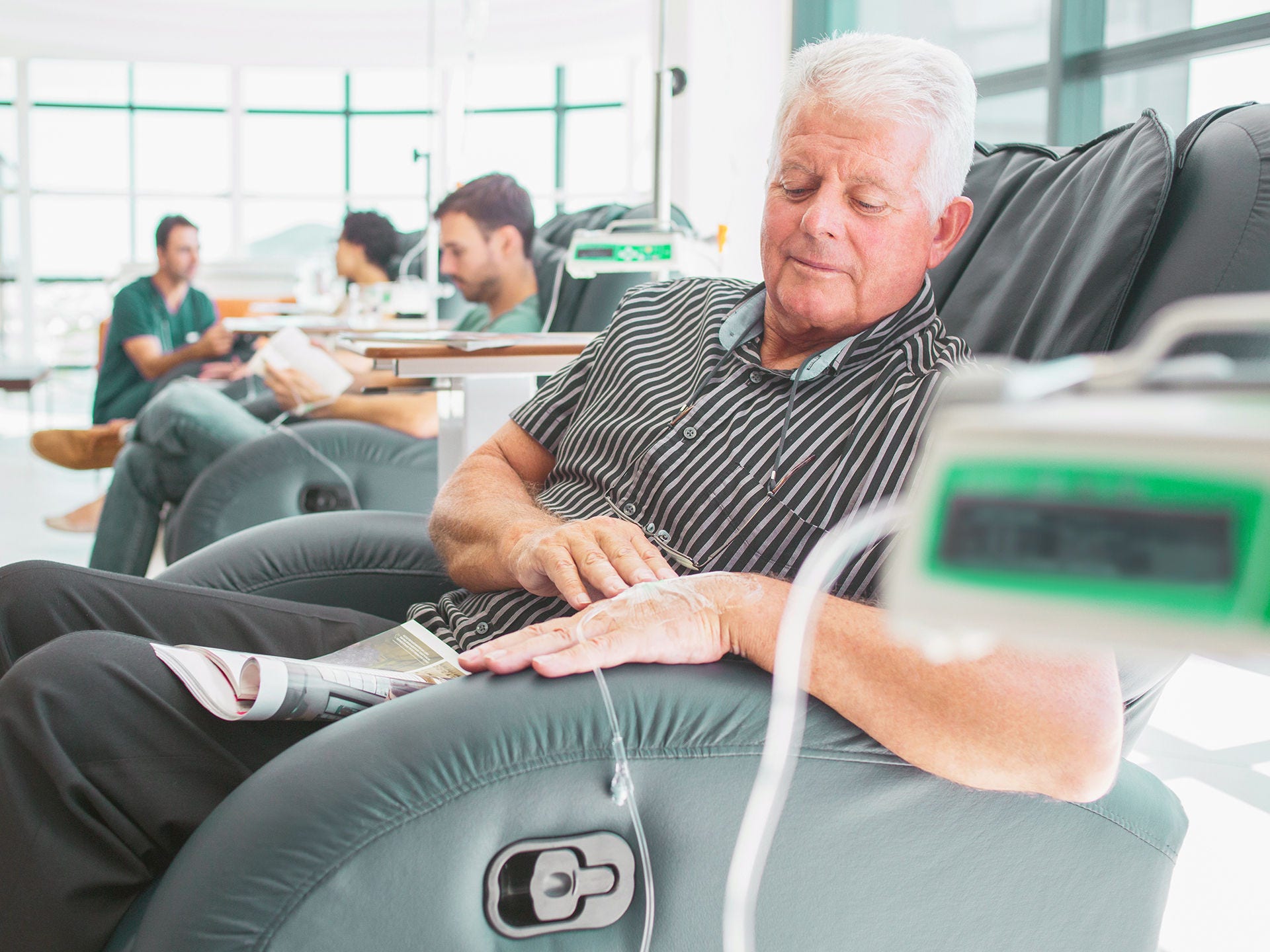 Mann sitzt in einem ambulanten Behandlungsraum und erhält eine Chemotherapie. Das individuelle Corona-Risiko hängt unter anderem von der Aktivität und dem Verlauf der Krebserkrankung, dem Alter sowie weiteren bestehenden Erkrankungen ab.