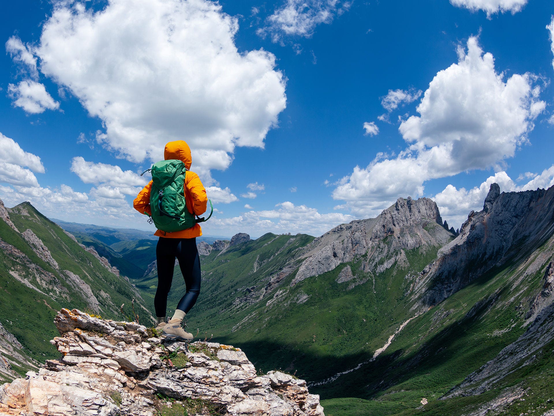 Person mit Rucksack blickt vom Berggipfel in die Ferne. Menschen mit COPD haben ein erhöhtes Risiko für schwere Corona-Verläufe.